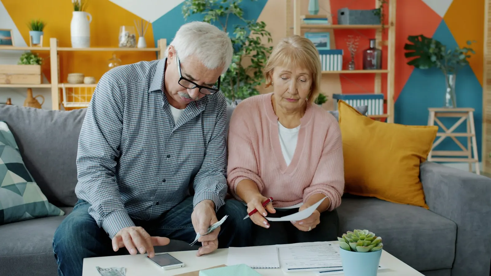 Couple de seniors qui étudie ses documents dans son salon