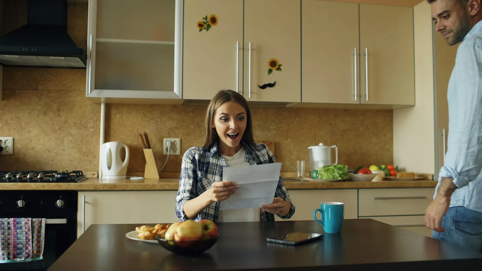 Femme lisant un courrier dans sa cuisine