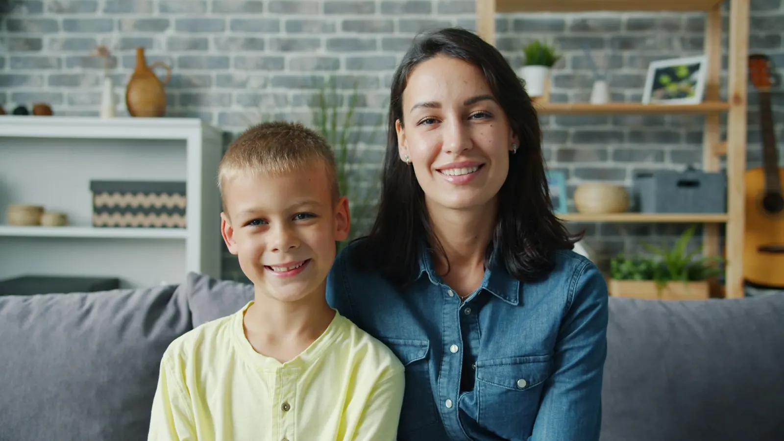 Mère et son fils souriants sur un canapé